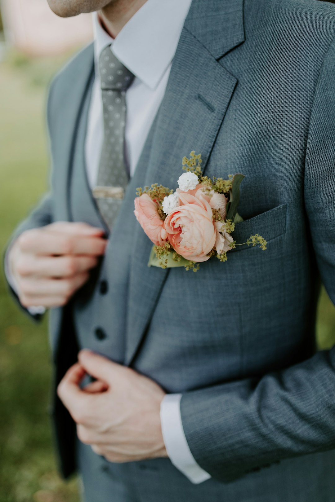 Groom in a tailored black wedding suit holding a bouquet, wedding suits Dubai